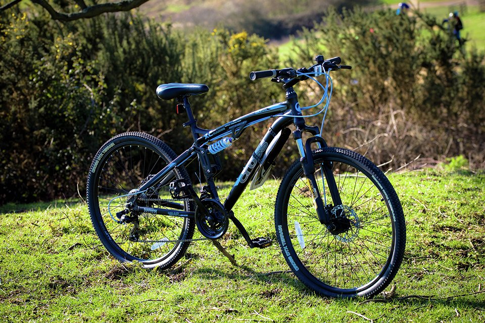 A Cross DXT700 26 inch Wheel Size Mens Mountain Bike parked outdoors.